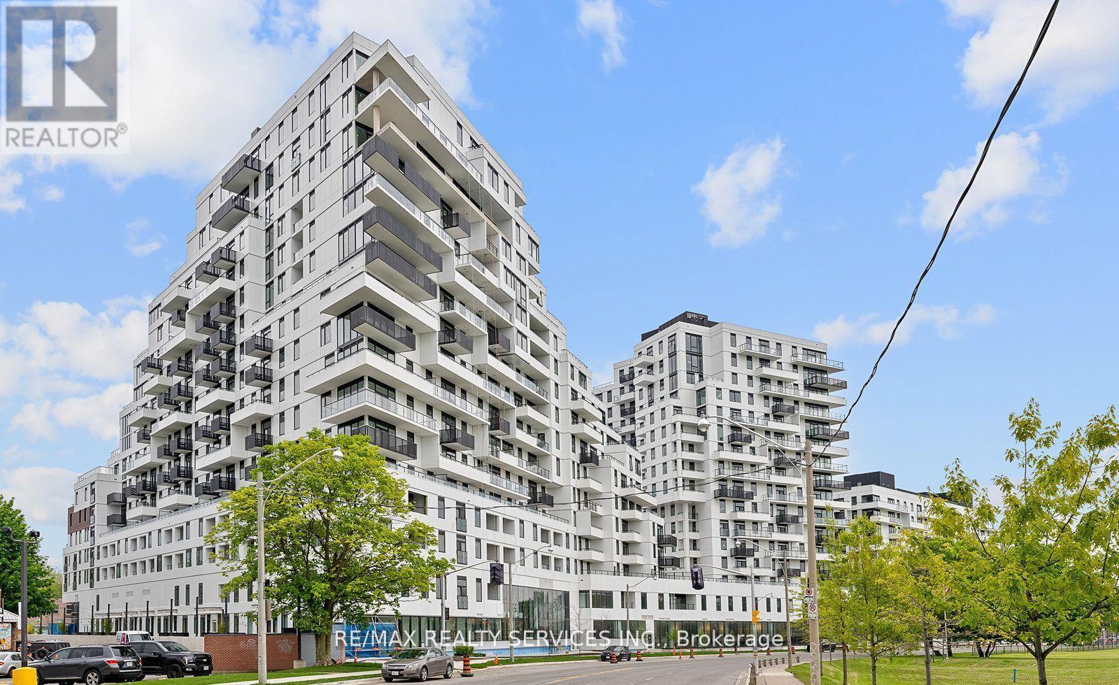 A modern multi-story residential building with balconies and a clear sky in the background.