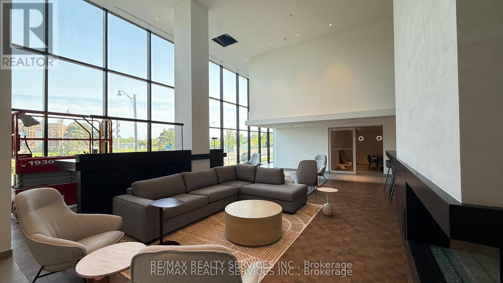 A spacious living room with a large window and a view of the city.