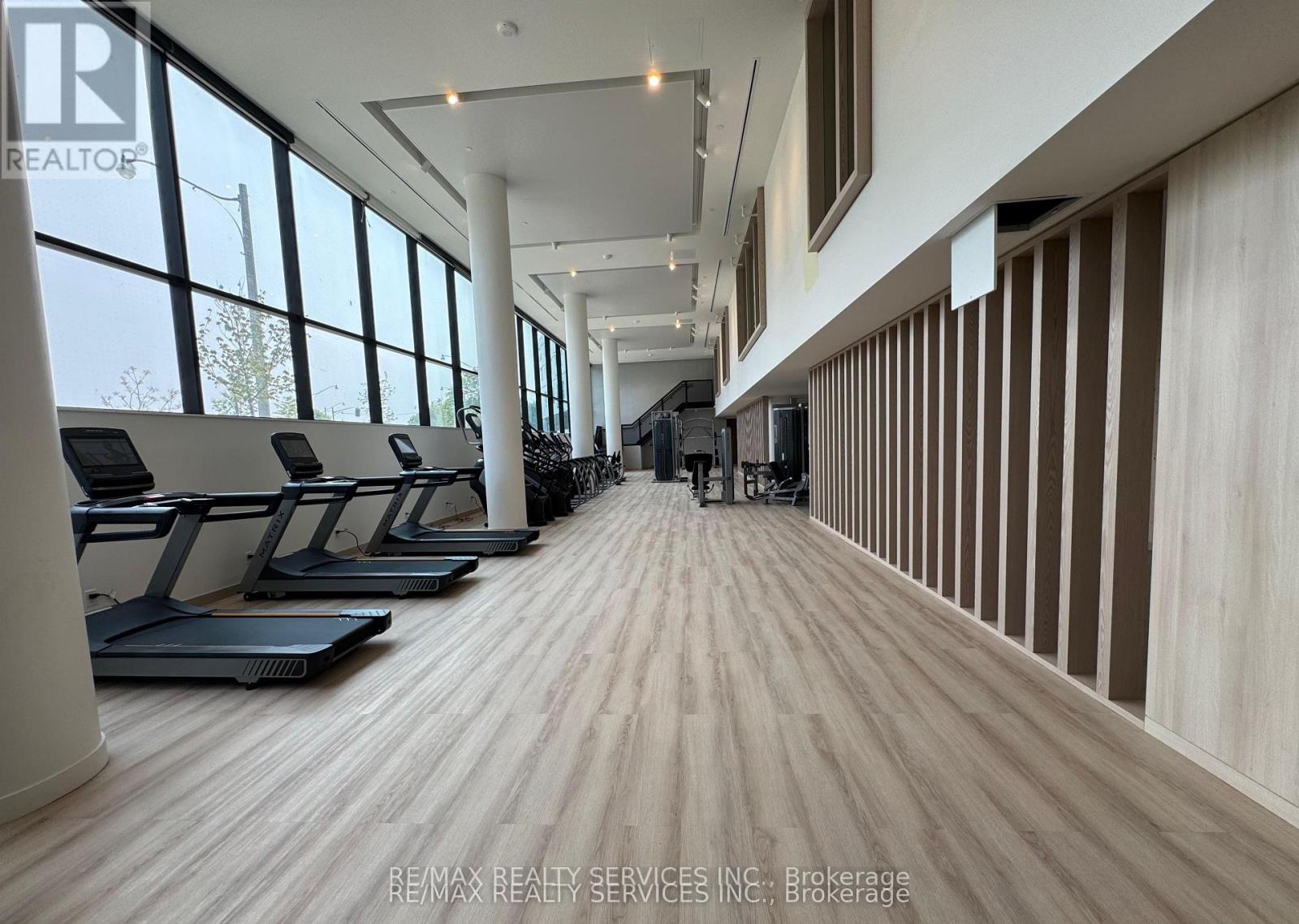 A spacious room with treadmills and a large window.
