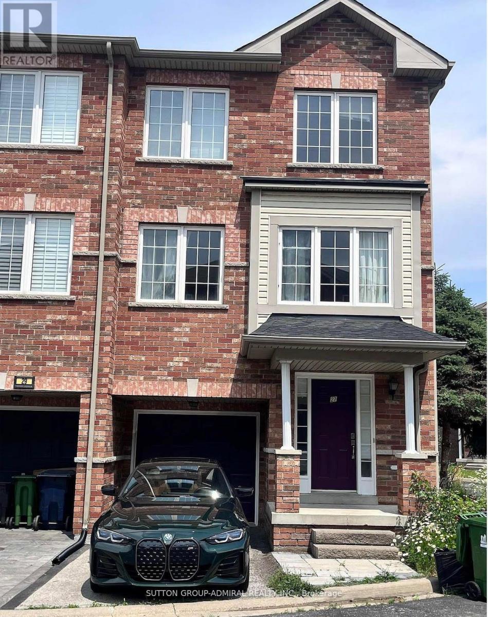 A BMW car is parked in front of a red brick house.