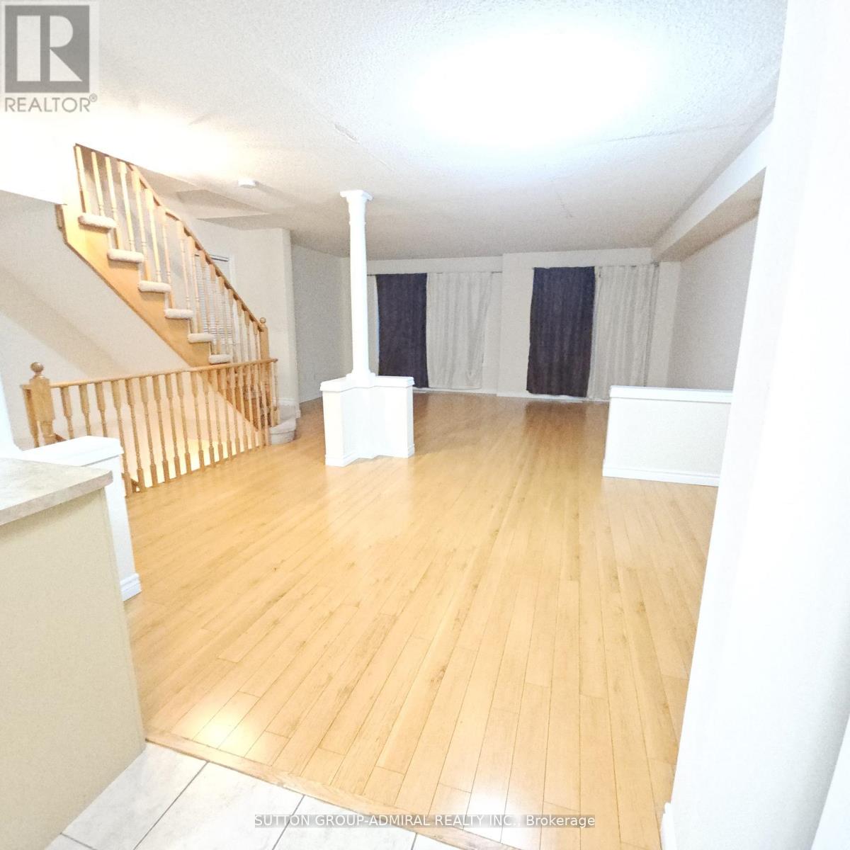 A room with wooden floors and a staircase with wooden railings.
