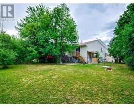 A house with a yard and trees in the background.