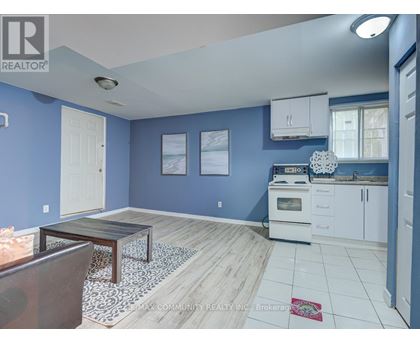 A kitchen with blue walls and white cabinets.