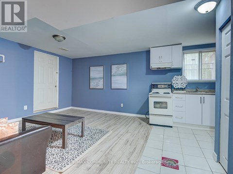 A kitchen with blue walls and white cabinets.