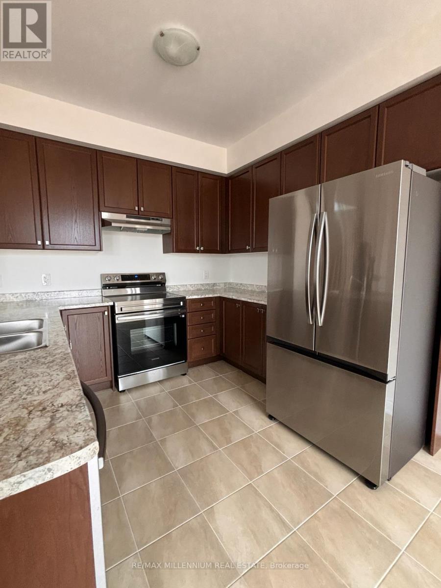 A kitchen with brown cabinets and a stainless steel refrigerator.