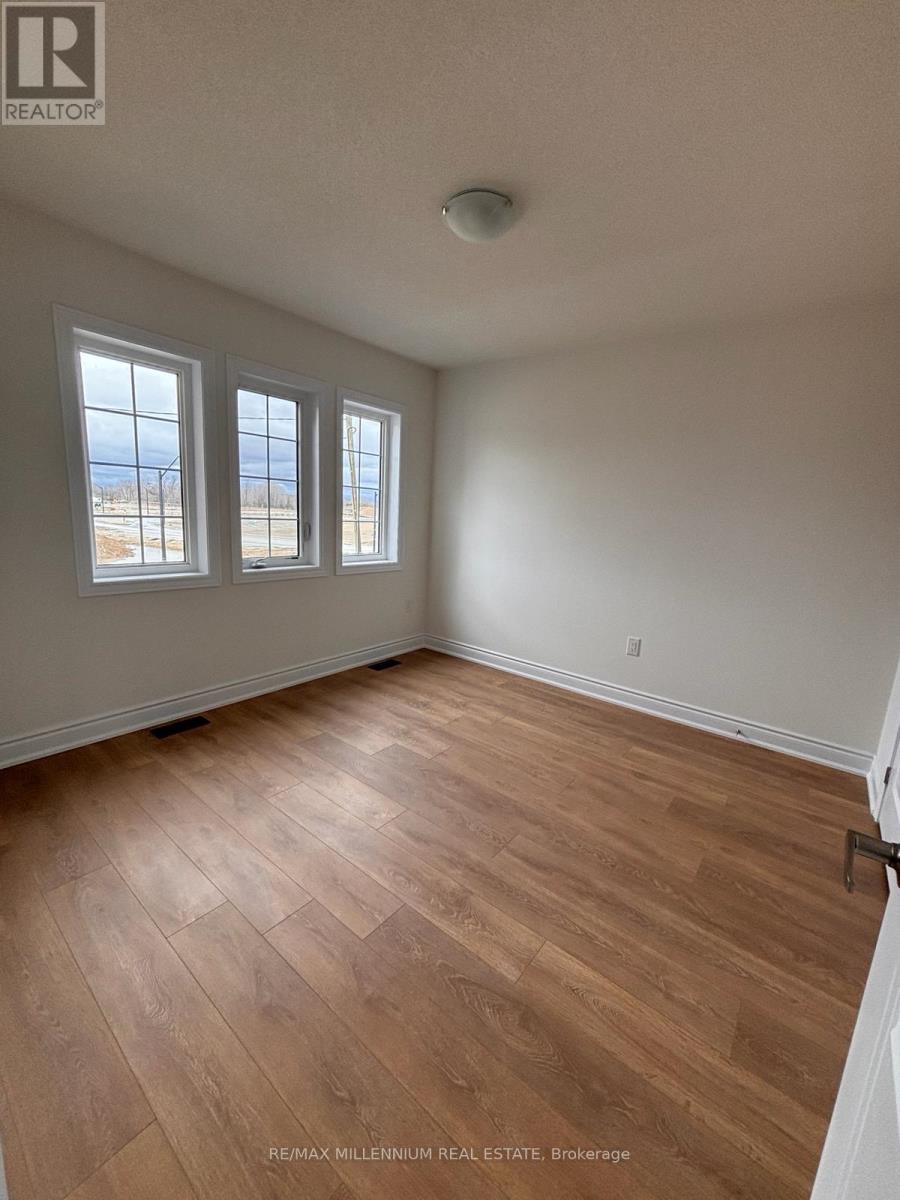 A room with a window and a wooden floor.
