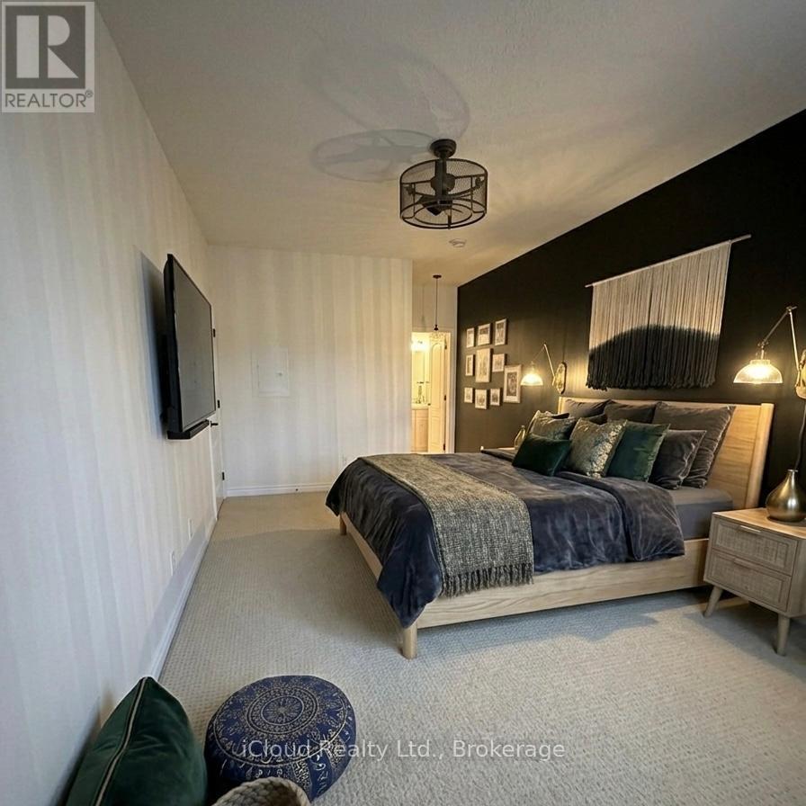 A bedroom with a bed, a ceiling fan, and a television mounted on the wall.