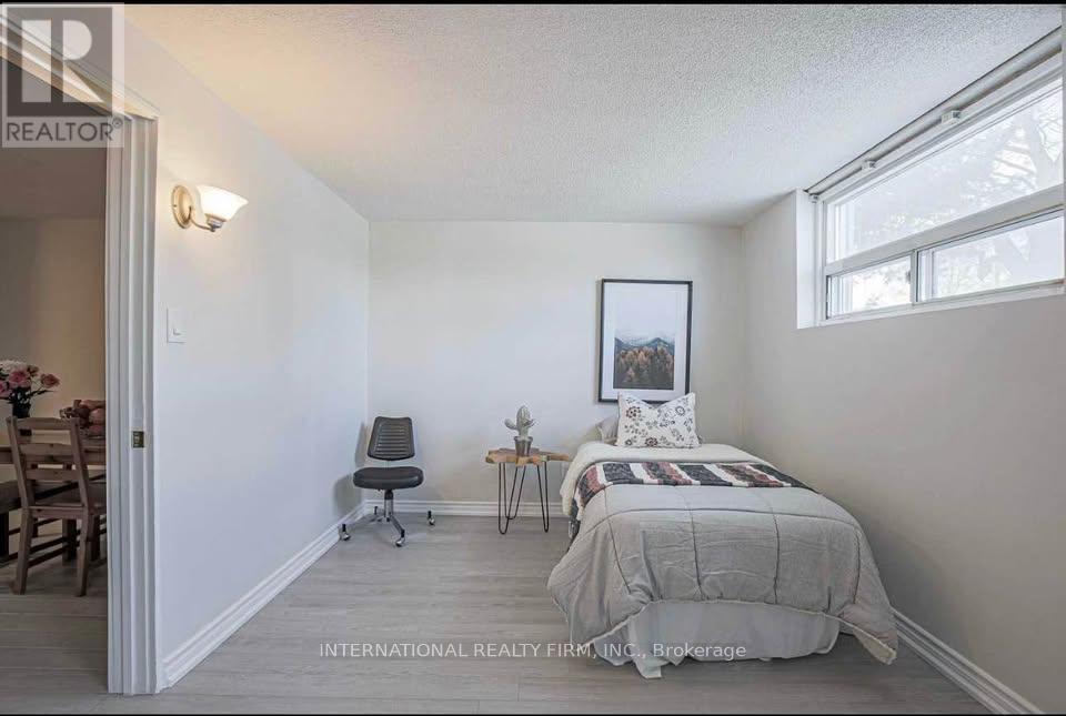 A bedroom with a bed, chair, and a painting on the wall.