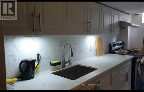 A kitchen with a sink, a coffee maker, and a cutting board.