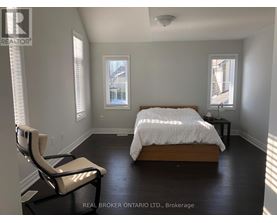 A bedroom with a bed, chair, and window.