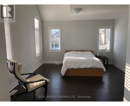 A bedroom with a bed, chair, and window.