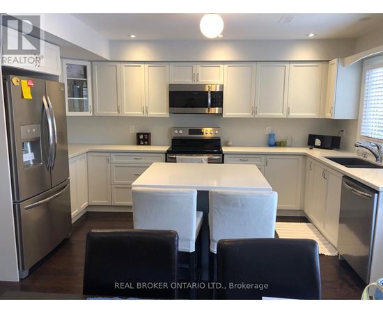 A kitchen with white cabinets and a refrigerator.