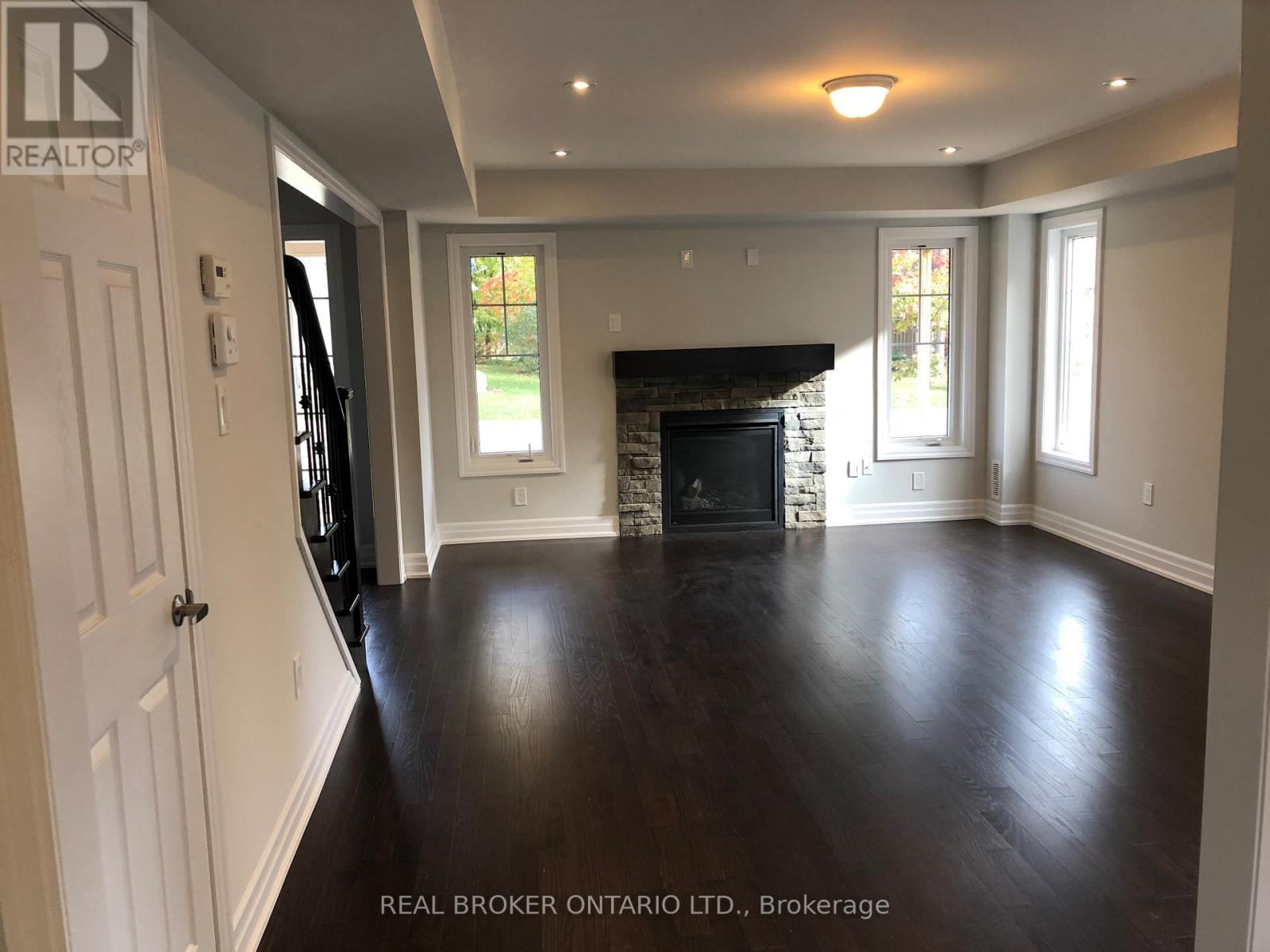 A spacious living room with a fireplace and hardwood floors.