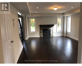 A spacious living room with a fireplace and hardwood floors.