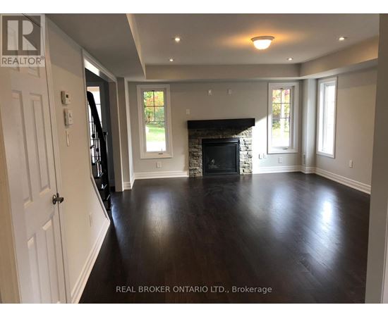 A spacious living room with a fireplace and hardwood floors.