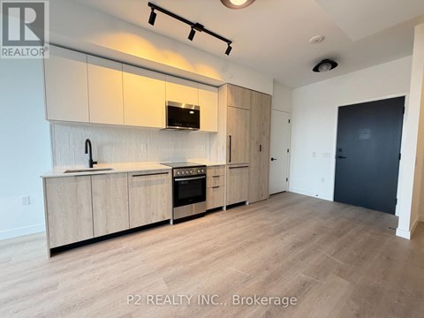 A kitchen with wooden cabinets and a black oven.
