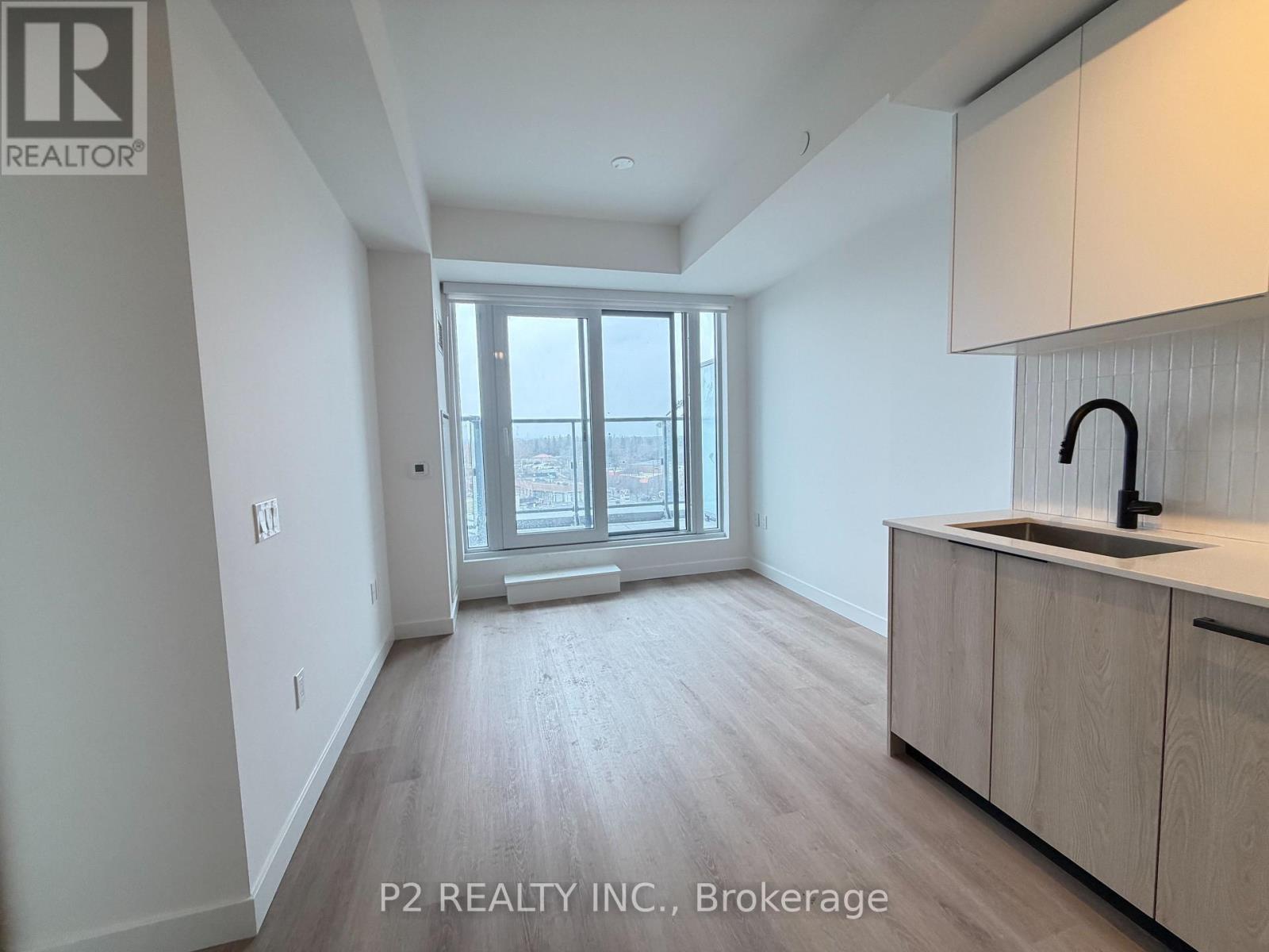 A spacious room with a window, sink, and cabinets.