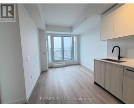 A spacious room with a window, sink, and cabinets.