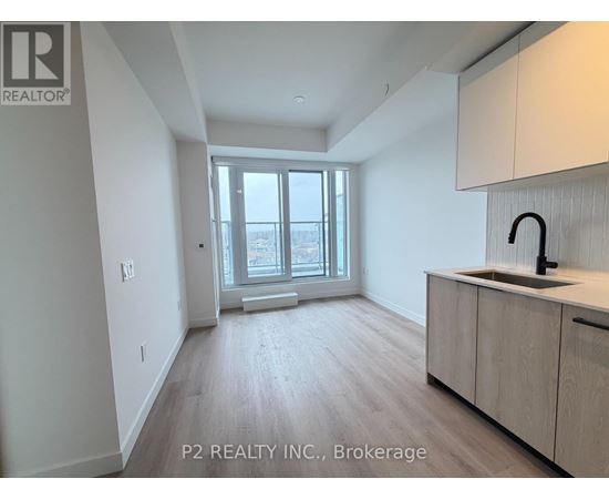 A spacious room with a window, sink, and cabinets.