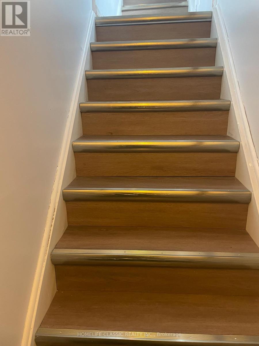 A set of wooden stairs with metal handrails.