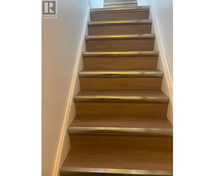 A set of wooden stairs with metal handrails.