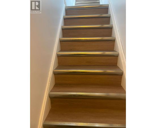 A set of wooden stairs with metal handrails.