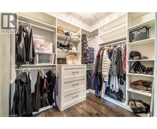 A spacious walk-in closet with neatly organized clothes and shoes.