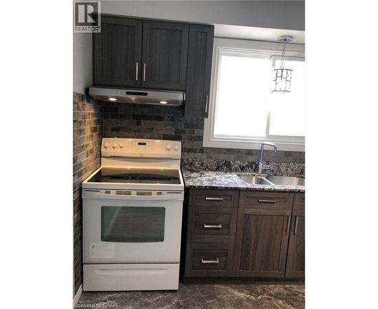 A white oven and stove top are in a kitchen with dark wood cabinets.