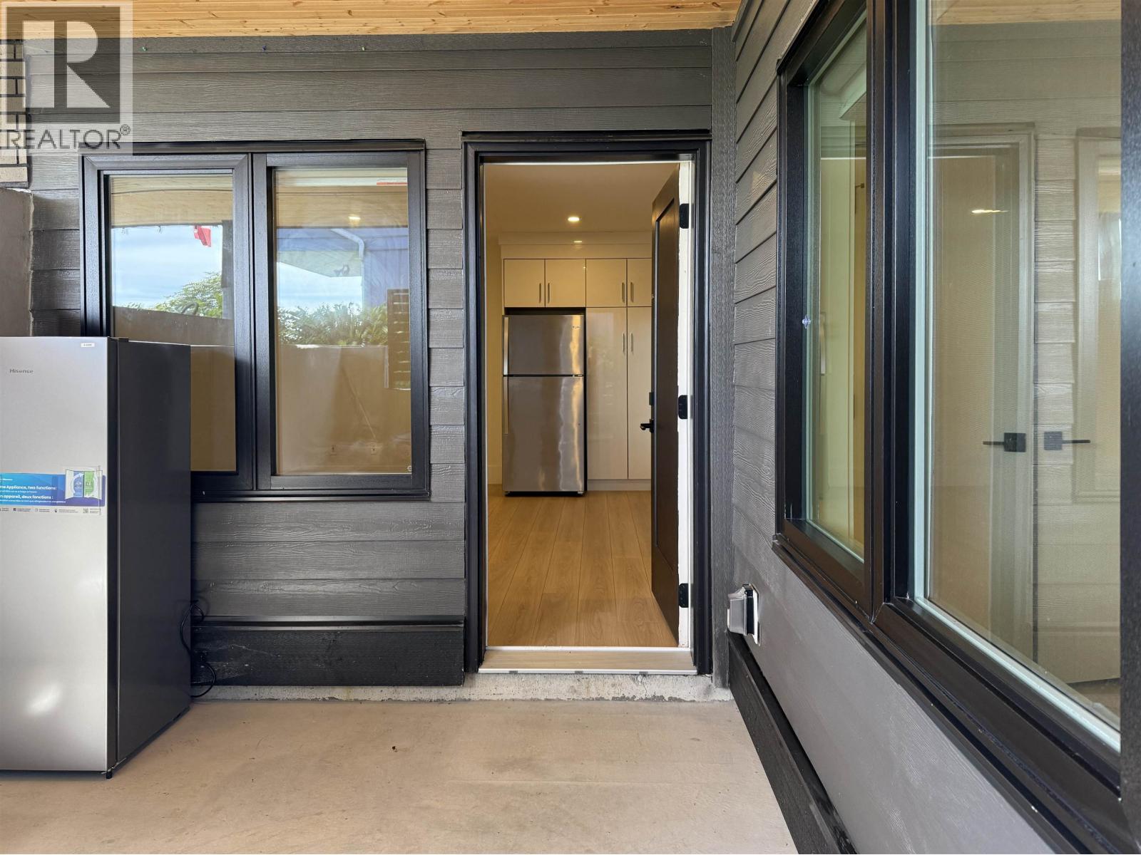 A modern house entrance with a glass door and a wooden door.
