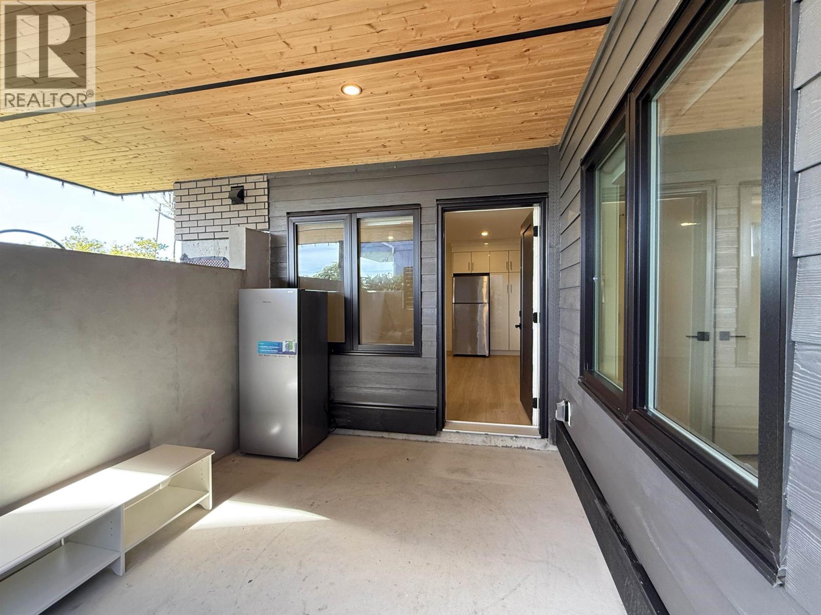 A modern house with a wooden ceiling and a glass door.
