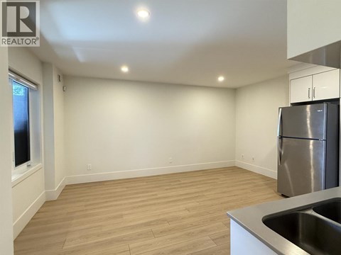 A kitchen with a refrigerator and a sink.