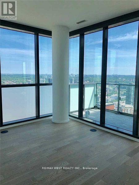A room with a view of the cityscape through large windows.