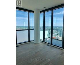 A room with a view of the cityscape through large windows.