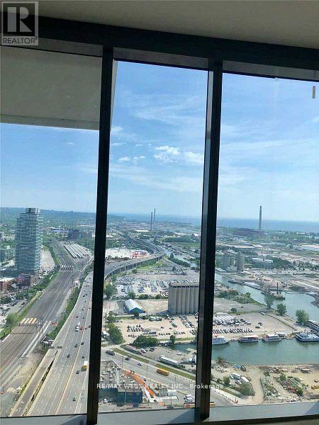 A view from a high-rise window looking out at a busy highway and a body of water.