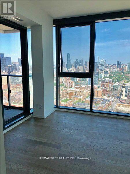 A room with a view of the city skyline through large windows.