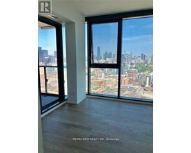 A room with a view of the city skyline through large windows.