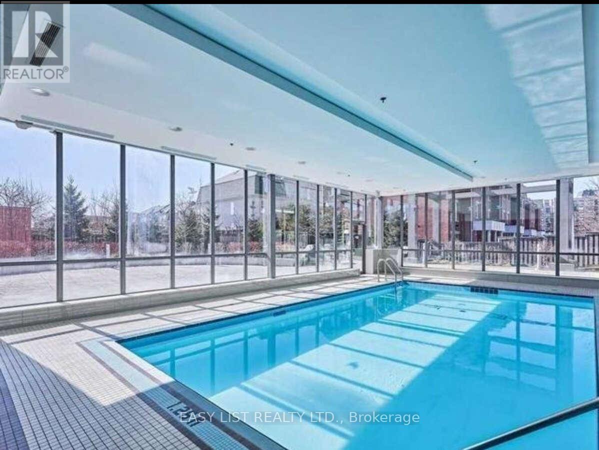 A large indoor swimming pool with a glass wall surrounding it.