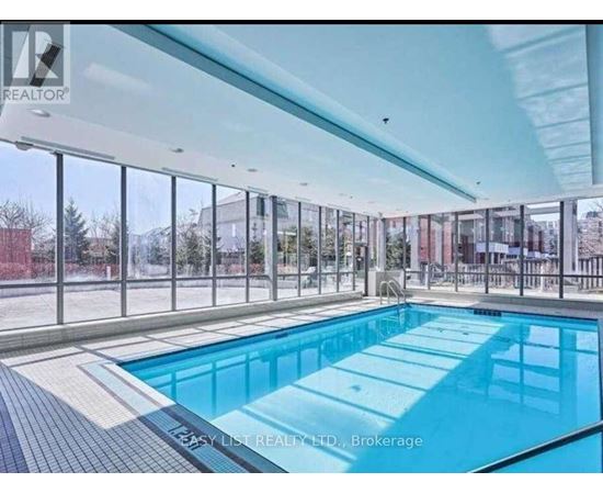 A large indoor swimming pool with a glass wall surrounding it.