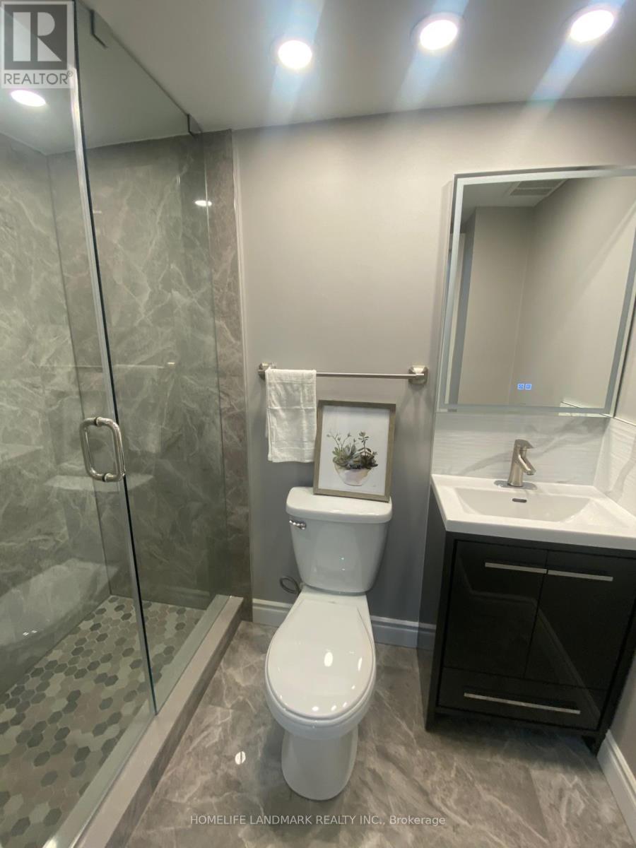A bathroom with a toilet, sink, and shower.