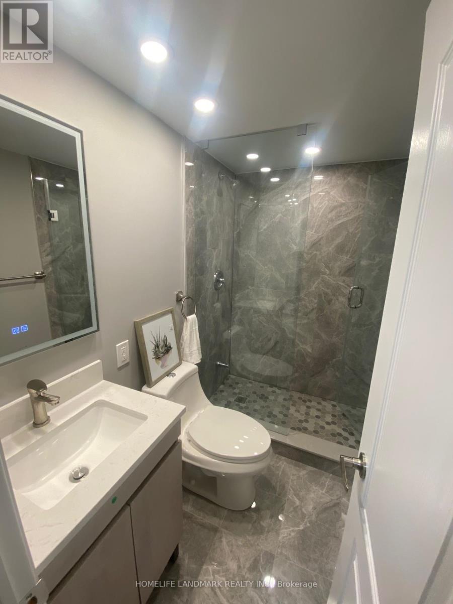 A bathroom with a toilet, sink, and shower.