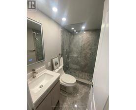 A bathroom with a toilet, sink, and shower.
