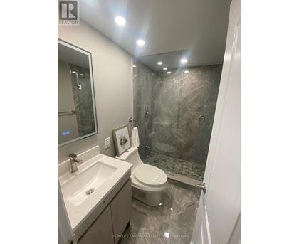 A bathroom with a toilet, sink, and shower.
