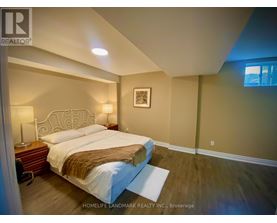 A bedroom with a large bed and a wooden nightstand.