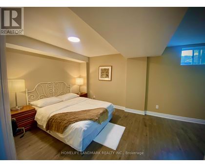 A bedroom with a large bed and a wooden nightstand.