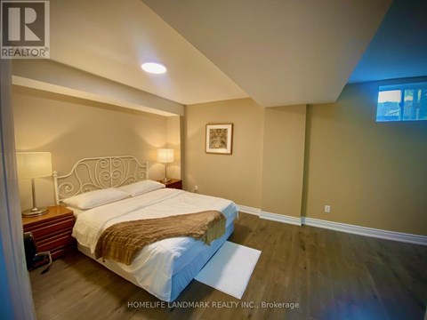A bedroom with a large bed and a wooden nightstand.