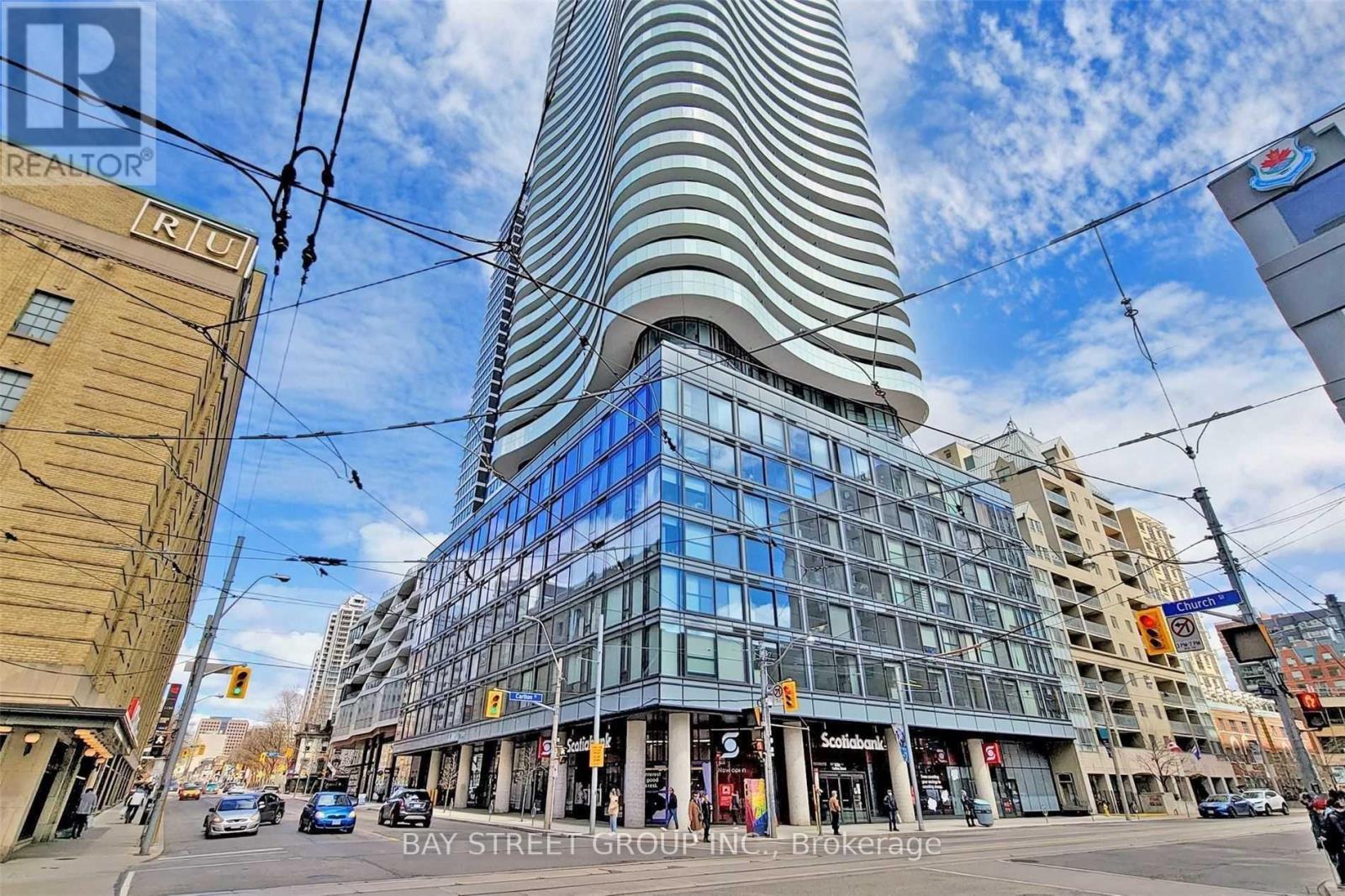 A tall building with a curved facade dominates the city street scene.