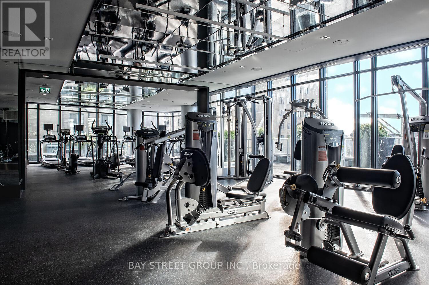 A gym with a variety of equipment including treadmills, weights, and exercise machines.