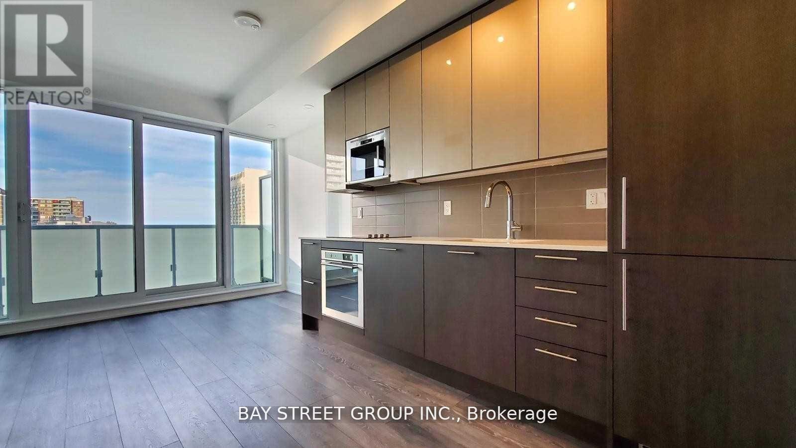 A modern kitchen with dark wood cabinets and a stainless steel oven.