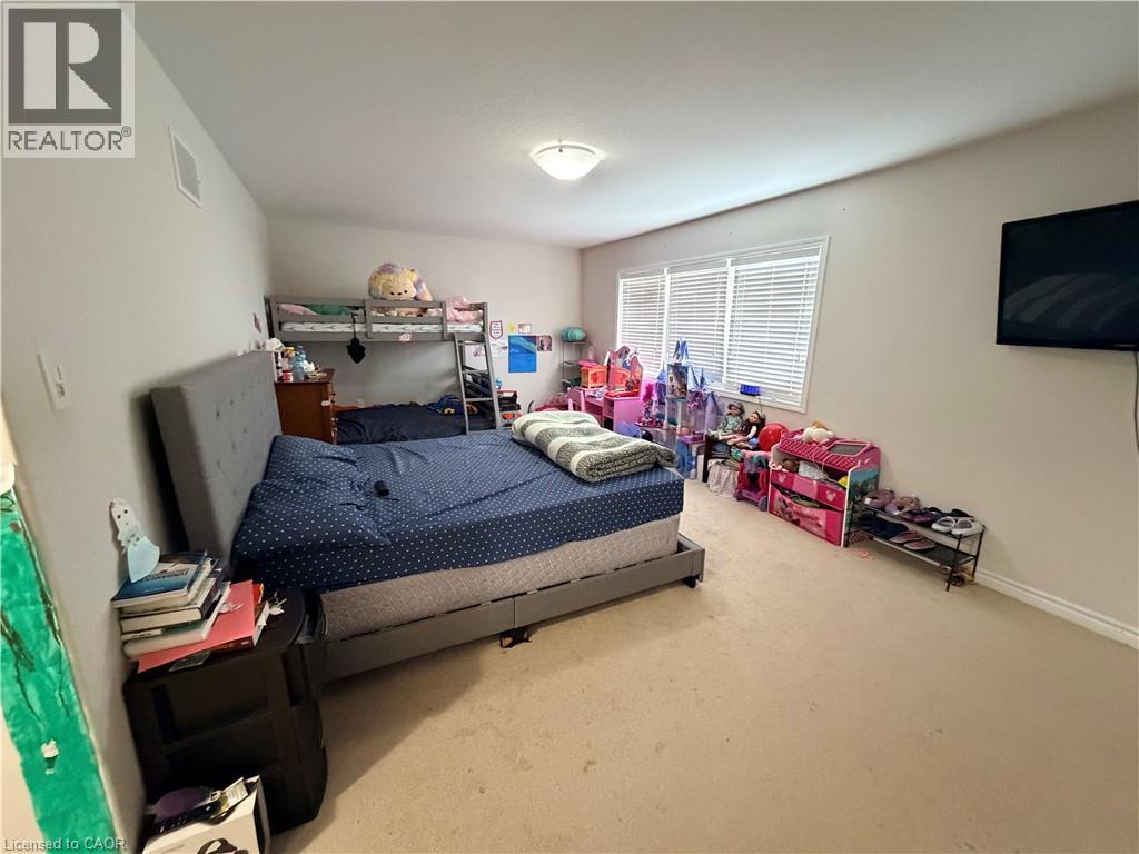 A bedroom with a bed, a shelf, and a TV.