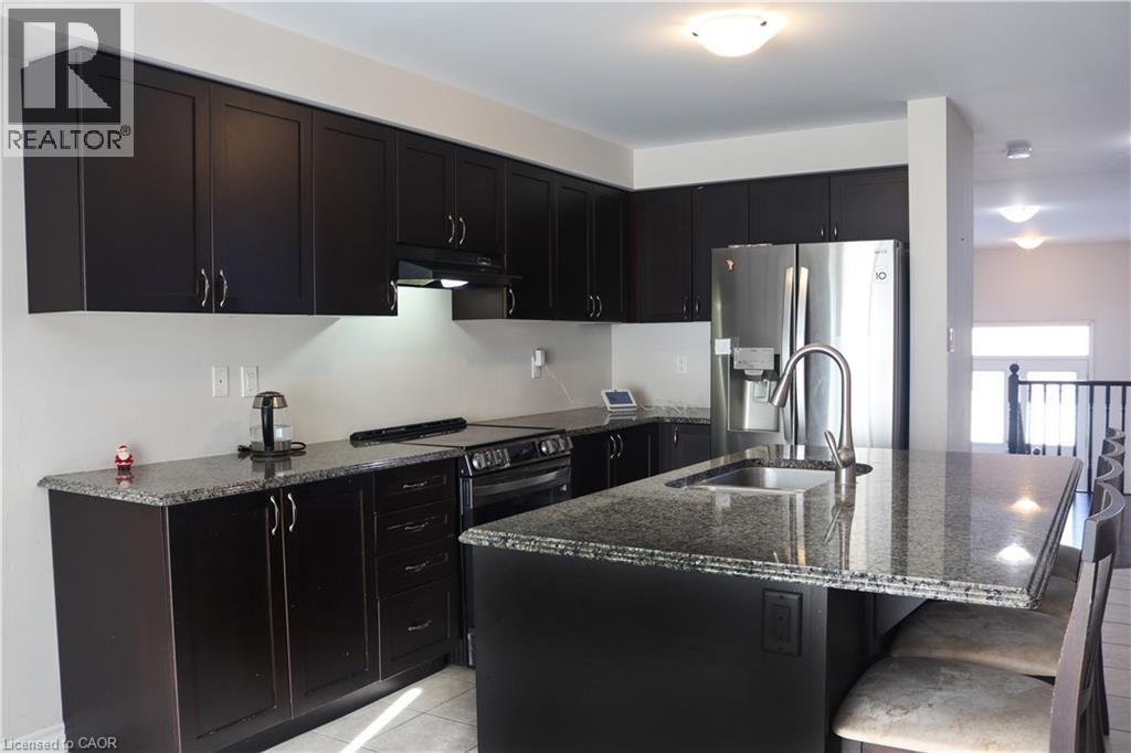 A kitchen with black cabinets and a granite countertop.